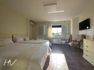 a hotel room with two beds and a television at Hostal Valderas in Valderas