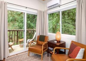 sala de estar con 2 sillas y 2 ventanas en Relaxing Tree House in Sequim, Washington, Perfect for a Glamping Getaway to Olympic National Park, en Sequim