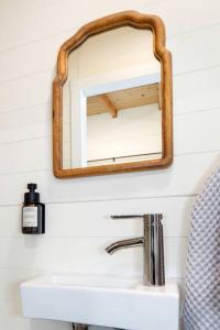 espejo sobre un lavabo en el baño en Relaxing Tree House in Sequim, Washington, Perfect for a Glamping Getaway to Olympic National Park, en Sequim