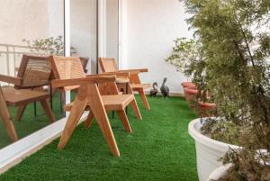 a patio with wooden tables and chairs on the grass at Homestay 3 Bhk Apartment with balcony Near Chandigarh Airport IT city Mohali in Mohali