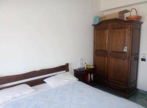Un dormitorio con una cama y un armario de madera. en Splendido appartamento a Soverato fronte mare, en Soverato Marina