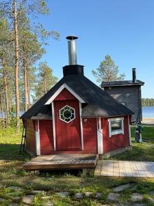 una casa roja con techo negro y una ventana en Aurora cottage, en Oulu