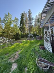 a yard next to a house with a swing at Aurora cottage in Oulu