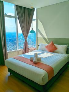 クアラルンプールにあるSky Suites KLCC Kuala Lumpur LBの大きなベッドと大きな窓のある寝室