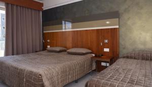 a hotel room with two beds in a bedroom at Topaz Hotel in St Paul's Bay