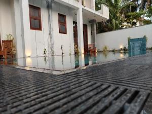 a house with a swimming pool next to a building at Villa White Elephant in Hikkaduwa