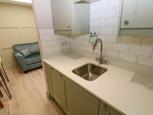 eine Küche mit Spüle und blauem Stuhl in der Unterkunft Cosy Cottage 5 in Durham