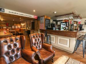 eine Bar mit zwei Ledersesseln und einer Theke in der Unterkunft Cosy Cottage 5 in Durham