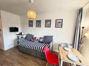Una sala de estar con una cama, una mesa y sillas. en Apartment Les Normandières-24 by Interhome, en Cabourg