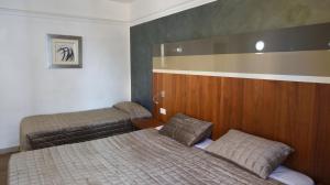 a small bedroom with two beds and a headboard at Topaz Hotel in St Paul's Bay