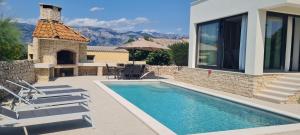 a villa with a swimming pool and a house at Villa Emma - luksuzna kuća s bazenom Wellness & SPA in Ražanac