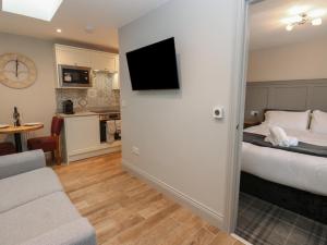 ein Hotelzimmer mit einem Bett und einem Fernseher an der Wand in der Unterkunft Cosy Cottage 4 in Durham