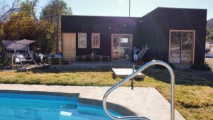 a small black house with a pool in front of it at Terrario Elqui Cabañas in Vicuña +1 photo