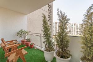 a balcony with potted plants and a wooden bench at Homestay 3 Bhk Apartment with balcony Near Chandigarh Airport IT city Mohali in Mohali