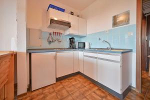a kitchen with white cabinets and a sink at FeWo Zeidler Nr42 Sol Mare in Kellenhusen