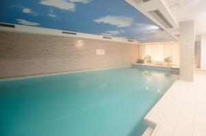 a large swimming pool with a blue ceiling at FeWo Zeidler Nr42 Sol Mare in Kellenhusen +3 photos