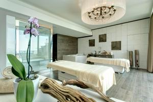 a room with two beds and a vase with purple flowers at Almar Jesolo Resort & Spa in Lido di Jesolo