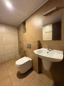 a bathroom with a white toilet and a sink at Crystal inn BY D2V in Kakkanad