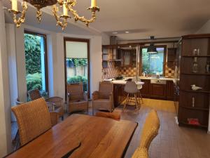 a dining room with a table and a kitchen at Biały Domek dla 8 osób oraz Domek Sternika dla 4 osób - jezioro, las, wiejski klimat in Międzychód