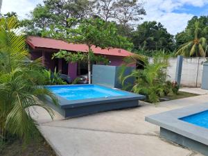 a swimming pool in front of a house at Centro Vacacional el Amanecer in Puntarenas