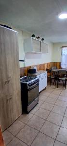 a kitchen with a stove and a table in it at Mi casa, tu casa in Punta Arenas