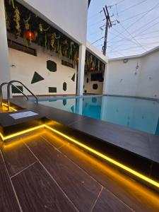 a swimming pool with lights on the side of a building at Suna'a home Logpom in Douala