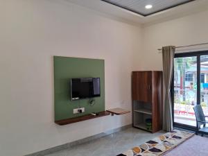 a living room with a flat screen tv on a wall at The Betelnut A Boutique Stay in Nagaon
