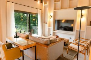 a living room with a couch and a tv at Iguazu Jungle Lodge in Puerto Iguazú