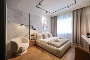 ein Schlafzimmer mit einem Bett, einem Stuhl und einem Fenster in der Unterkunft Estium Heritage Rooms in Zadar