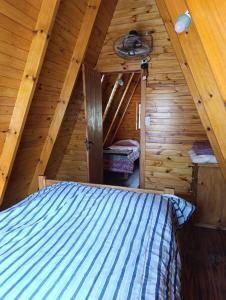 a bedroom in a log cabin with a bed at Alpinas Aliwé in San Ignacio +18 photos