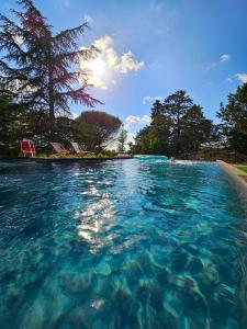 a view of a body of water with chairs in it at Villa Les Roques in Saint-Vincent-Rive-dʼOlt