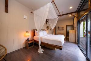 a bedroom with a bed with a mosquito net at Lov Faralya Adults Only in Faralya