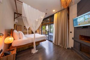 a bedroom with a bed with a mosquito net at Lov Faralya Adults Only in Faralya