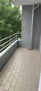 a balcony of a building with a fence and trees at Zen Hafen 3 - 3 bedrooms - balcony - kitchen - washing machine in Bremerhaven