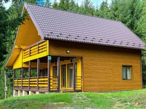 a small wooden house with a large deck at Котедж Forest house in Verkhovyna
