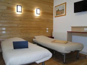 a room with two beds with a laptop on them at Village Vacances Passion Georges Moustaki in Les Moussières