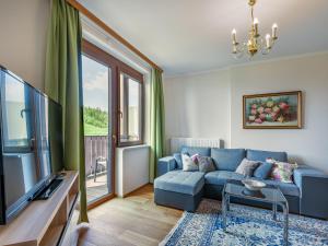 a living room with a blue couch and a tv at Apartment Simonhöhe-3 by Interhome in Sankt Paul +43 photos