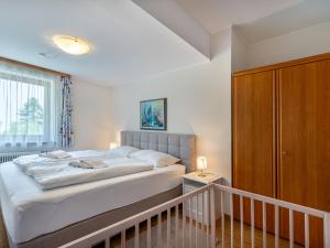 een slaapkamer met een groot bed en een houten kast bij Apartment Hocheck by Interhome in Sankt Paul