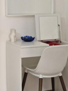 a white desk with a chair and a mirror at Cosy Corner in Tollo +5 photos