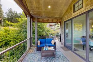 a porch with a blue chair and a table at Alta Vista in Pacific City