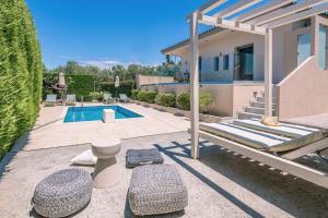 Un patio trasero con piscina y una casa. en Villa Vatia 1, en Tragaki