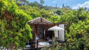 a resort with a deck with an umbrella and trees at Lov Faralya Adults Only in Faralya