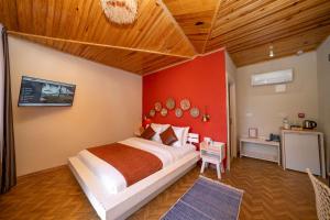 a bedroom with a large bed with a red wall at Lov Faralya Adults Only in Faralya