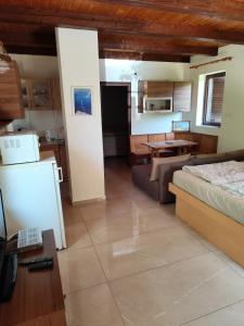 a living room with a bed and a kitchen at Balassa Weekendhouse in Siófok