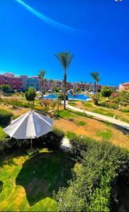 a white umbrella sitting in the grass in a park at Porto matrouh chalets for family in Marsa Matruh