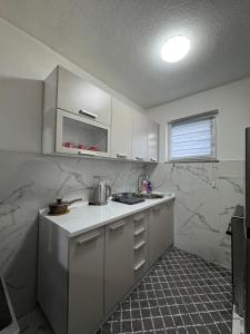 a kitchen with white appliances and marble walls at Villa Nature Konjic in Konjic