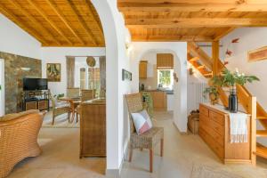 a kitchen and living room with wooden ceilings at CASA PAVÃO (SALGADINHO - SELÃO DA EIRA) in São Teotónio