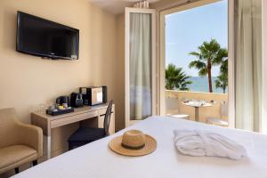 a hotel room with a table with a hat on it at Hotel Royalmar - Nouveau propriétaire in Cagnes-sur-Mer