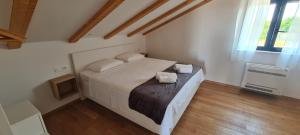 a large white bed in a room with wooden floors at Villa Emma - luksuzna kuća s bazenom Wellness & SPA in Ražanac +29 photos