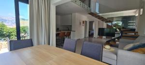 a dining room and living room with a table and chairs at Villa Emma - luksuzna kuća s bazenom Wellness & SPA in Ražanac